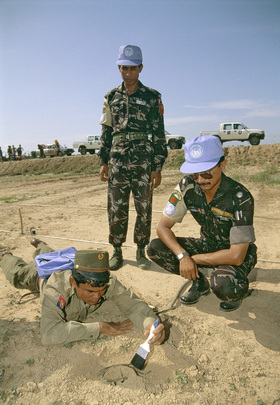 UNTAC - uczestnicy misji UNTAC uczą żołnierza armii Kambodży rozbrajania miny.